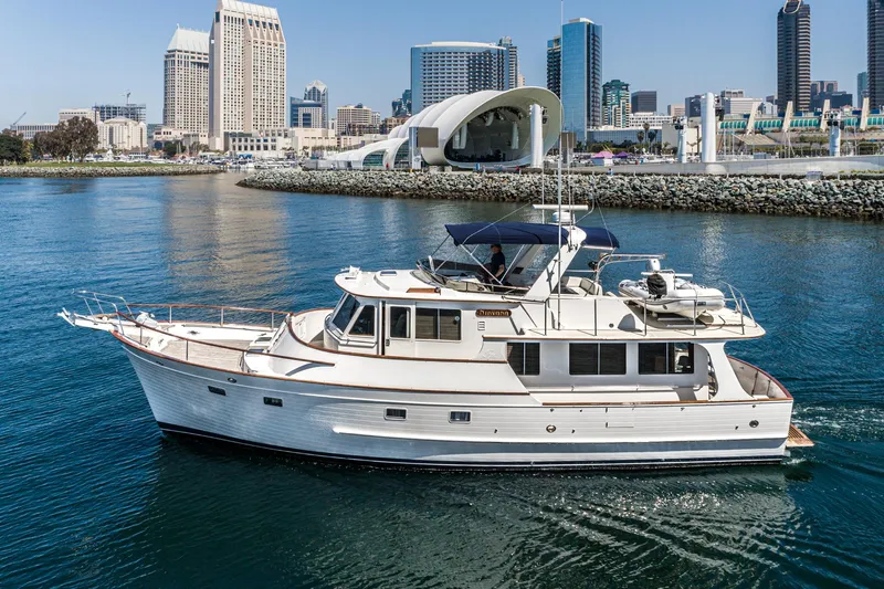 The Image of 1987 Fleming 50 Raised Pilothouse yacht cruising near urban waterfront skyline. - 0