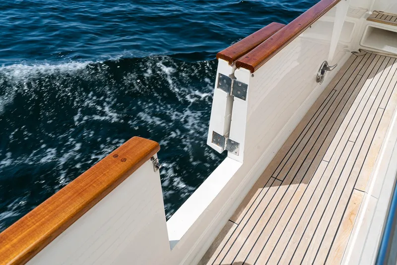 Slide: The Image of Deck view of 1987 Fleming 50 Raised Pilothouse yacht with teak railings and ocean waves. - 13