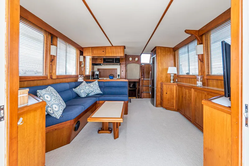 Slide: The Image of Luxurious interior of 1987 Fleming 50 Raised Pilothouse yacht with wooden furnishings and blue seating. - 15