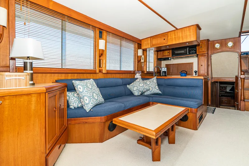 Slide: The Image of Luxurious interior of 1987 Fleming 50 Raised Pilothouse yacht with blue seating and wooden accents. - 16