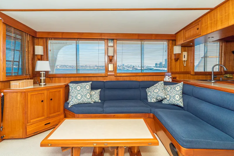 Slide: The Image of Luxurious 1987 Fleming 50 Raised Pilothouse interior with blue seating and wooden accents. - 17