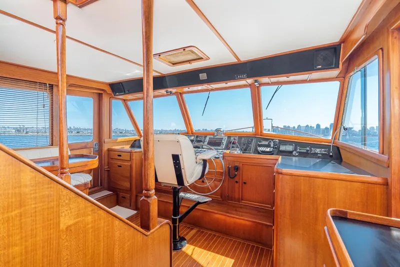 Slide: The Image of 1987 Fleming 50 Raised Pilothouse interior with wooden finish and panoramic windows. - 22