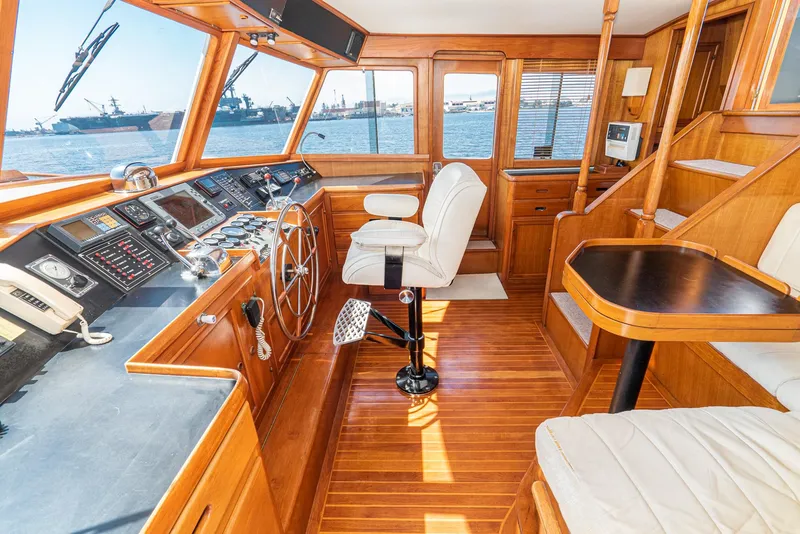 Slide: The Image of 1987 Fleming 50 Raised Pilothouse interior with wooden finish and navigational controls. - 23