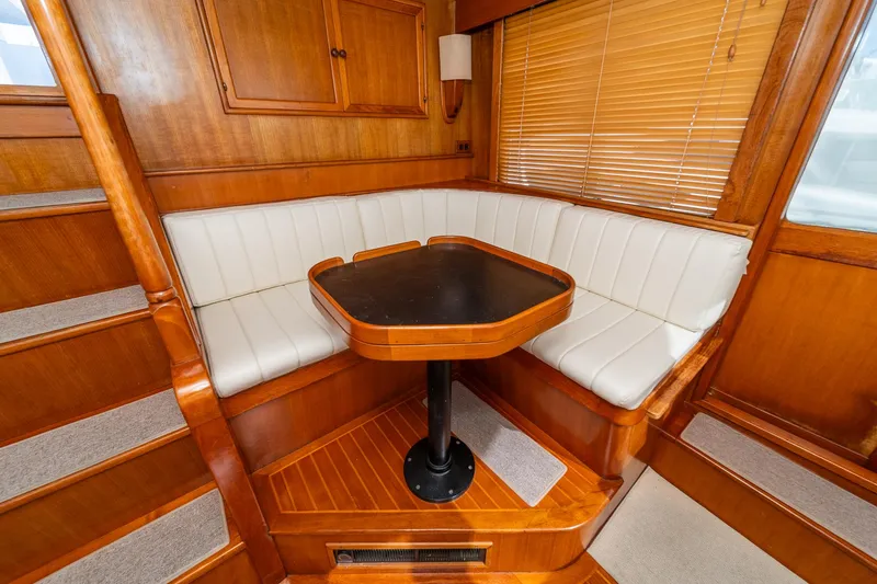 Slide: The Image of Cozy dining nook in 1987 Fleming 50 Raised Pilothouse with wood finish and white seating. - 25