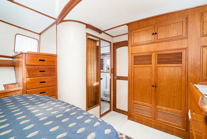 Slide: The Image of Interior of 1987 Fleming 50 Raised Pilothouse with wooden cabinetry and cozy bedroom. - 28