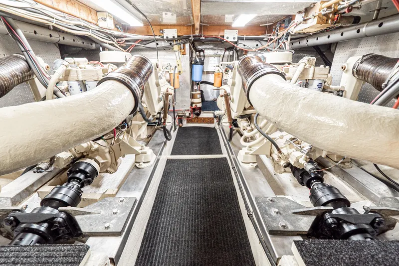 Slide: The Image of Engine room of a 1987 Fleming 50 Raised Pilothouse yacht, showcasing dual engines and mechanical systems. - 33