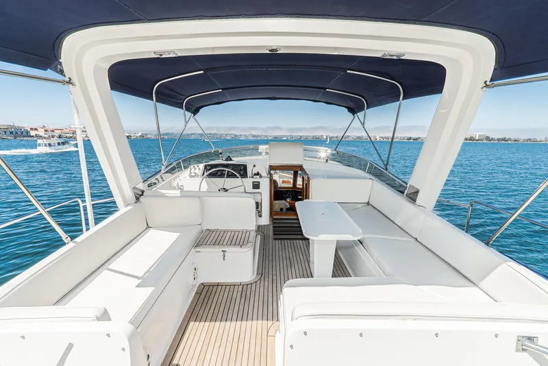 Slide: The Image of 1987 Fleming 50 Raised Pilothouse yacht with spacious deck and seating, cruising on blue waters. - 9