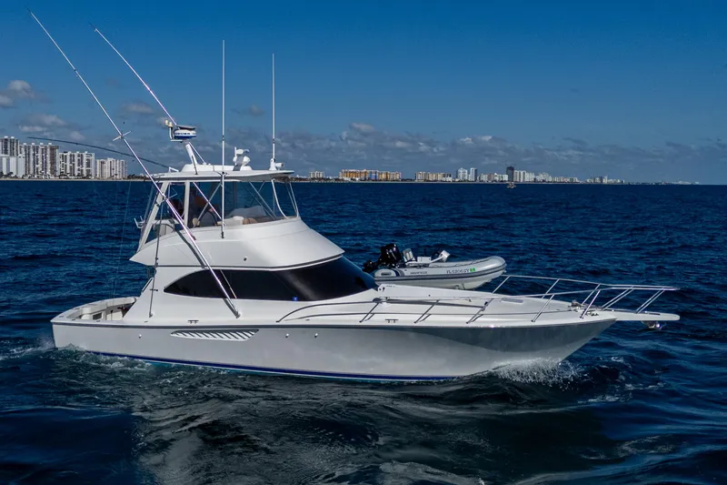 Slide: The Image of 2016 Viking 46 Convertible yacht cruising on open water under clear blue sky. - 0