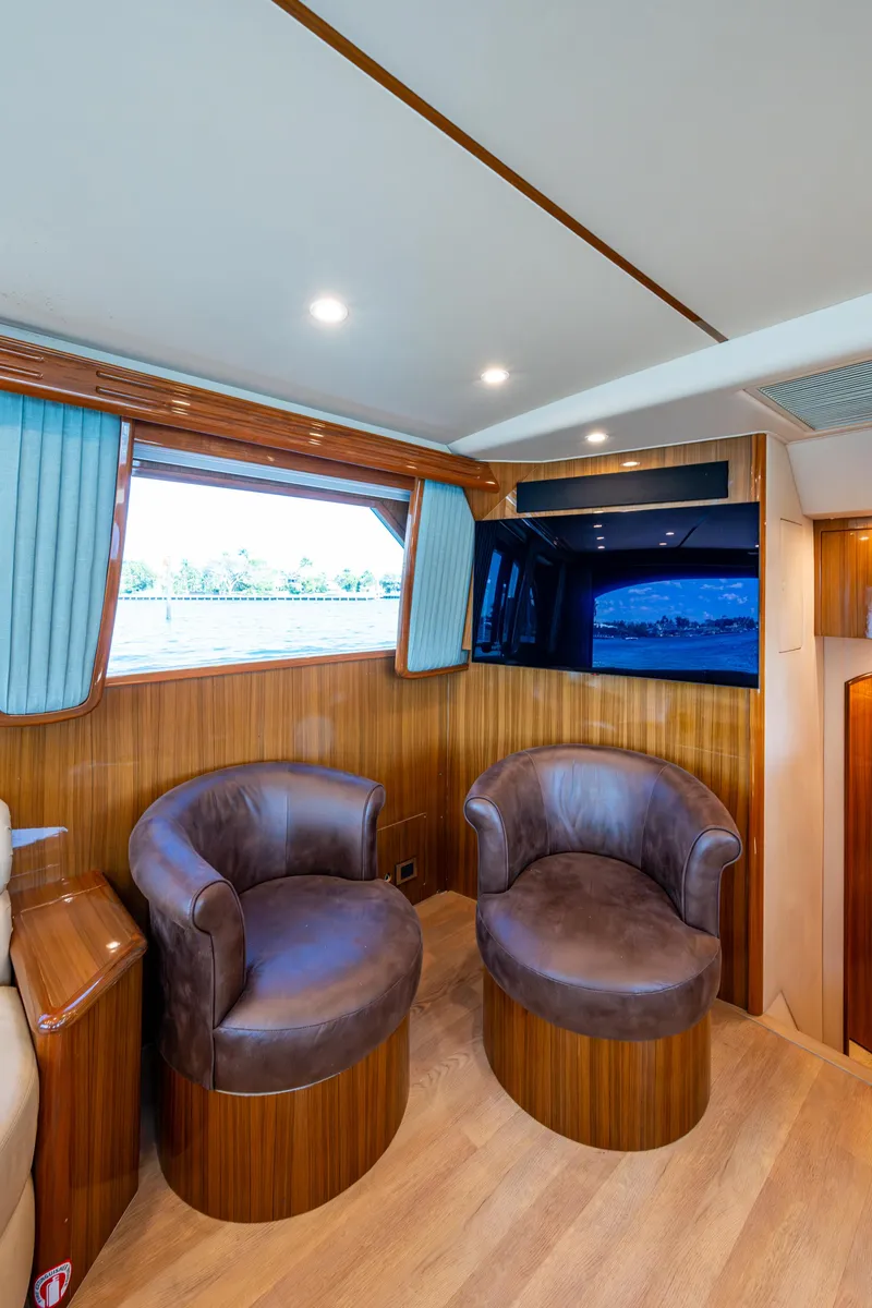 Slide: The Image of 2016 Viking 46 Convertible yacht interior with leather chairs and wood paneling. - 16