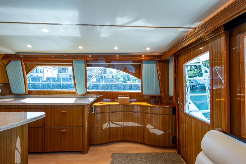 Slide: The Image of Interior of 2016 Viking 46 Convertible yacht with polished wood finish and large windows. - 17