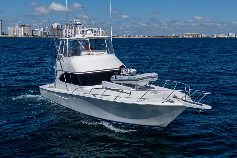 Slide: The Image of 2016 Viking 46 Convertible yacht cruising on ocean near city skyline. - 6