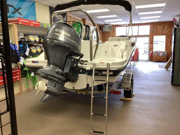 Slide: The Image of 2024 Hurricane SS-185 OB boat interior with white and gray seating, steering console, and carpeted floor. - 3