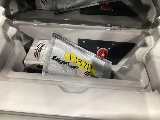 Slide: The Image of Storage compartment of 2024 ATX Surf Boats 22ATX with equipment and safety gear. - 18