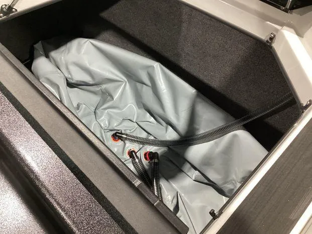 Slide: The Image of 2024 ATX Surf Boats 22ATX storage compartment with gray interior and hoses. - 22