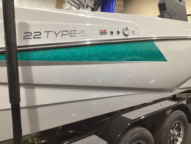 Slide: The Image of 2024 ATX Surf Boats 22ATX with teal accent, displayed on a trailer. - 7