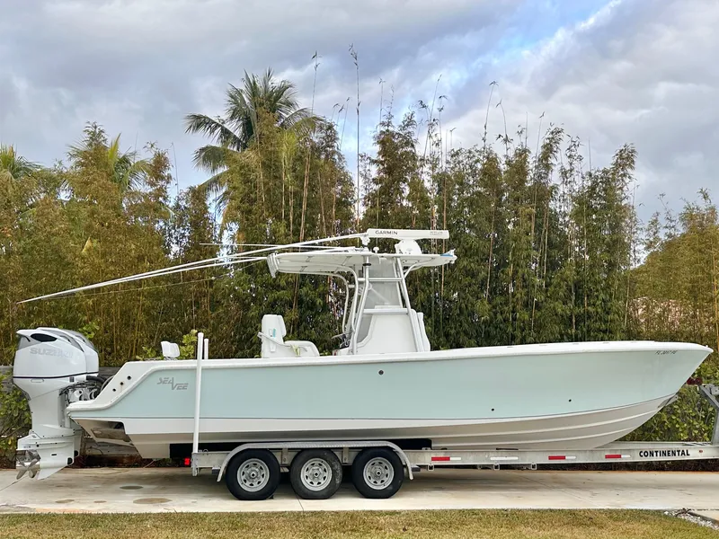 Slide: The Image of 2007 SeaVee 320B boat on trailer, parked outdoors with lush greenery background. - 0