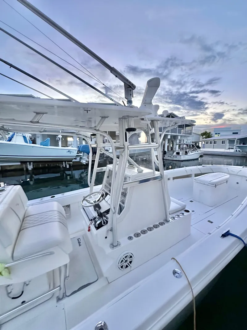 Slide: The Image of 2007 SeaVee 320B boat docked at marina during sunset, featuring sleek white design. - 6