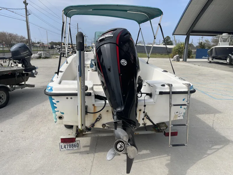 Slide: The Image of 1999 Bayliner 17cc boat with outboard motor and canopy, parked on concrete surface. - 4