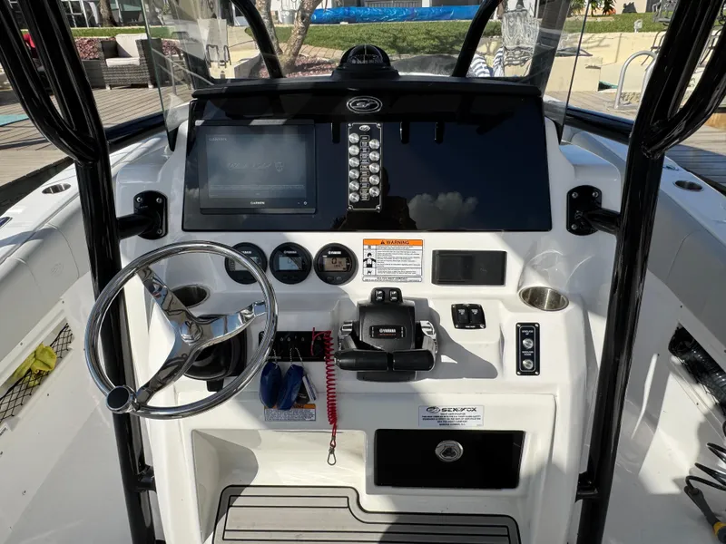 Slide: The Image of 2023 Sea Fox 268 Commander boat dashboard with steering wheel, controls, and navigation display. - 12