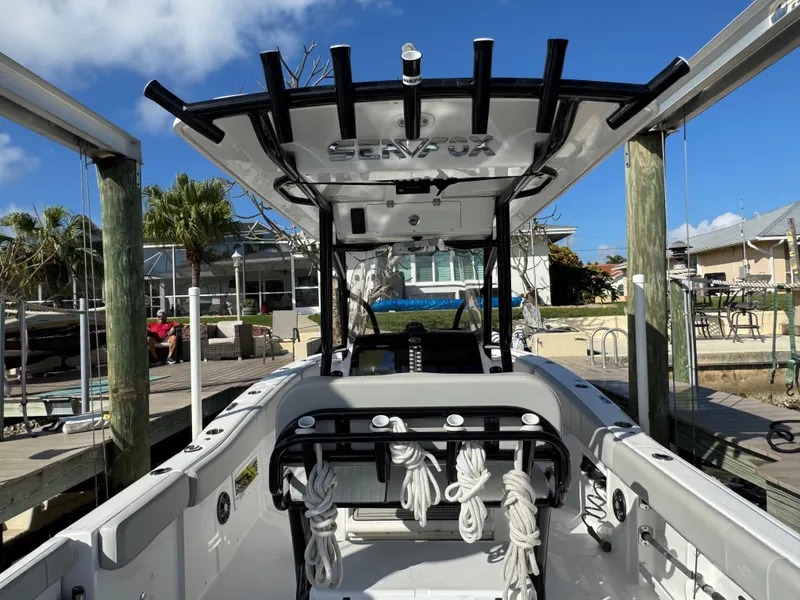 Slide: The Image of 2023 Sea Fox 268 Commander boat docked, showcasing interior and fishing rod holders. - 19