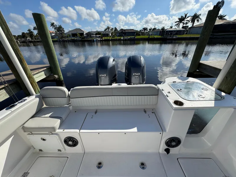 Slide: The Image of 2023 Sea Fox 268 Commander boat with dual engines docked by a serene waterfront. - 21