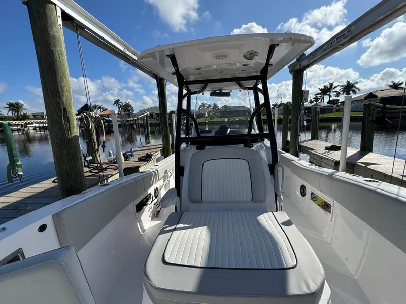 Slide: The Image of 2023 Sea Fox 268 Commander boat interior with seating, docked by a scenic waterfront. - 27