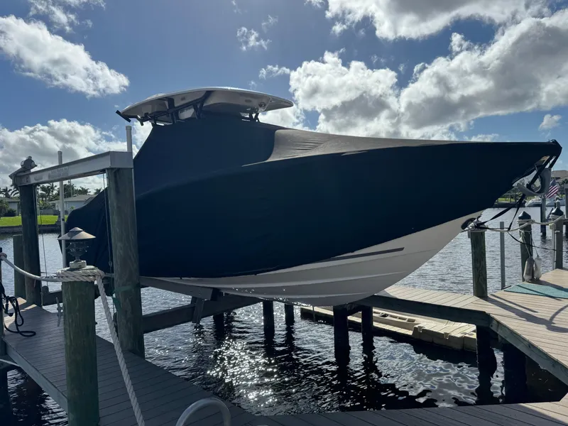 Slide: The Image of 2023 Sea Fox 268 Commander boat covered and docked under a cloudy sky. - 8