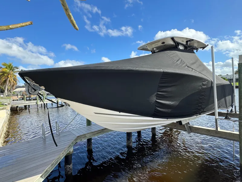 Slide: The Image of 2023 Sea Fox 268 Commander boat covered, docked by a sunny waterfront. - 9