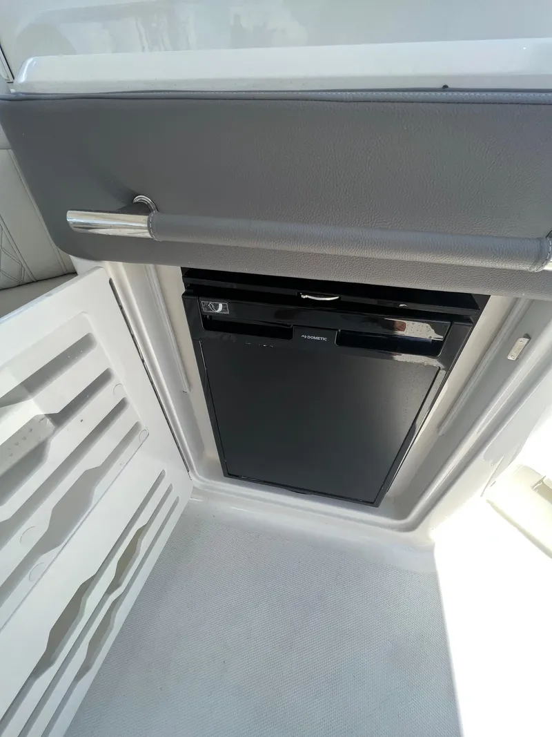 Slide: The Image of 2022 Sea Ray SLX 310 boat interior with built-in mini fridge. - 14