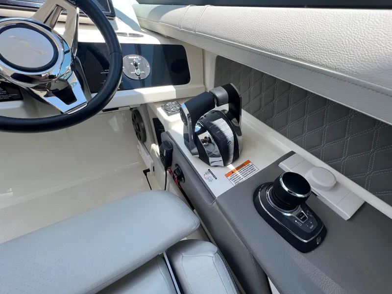 Slide: The Image of Interior of 2022 Sea Ray SLX 310 boat, featuring steering wheel and control panel. - 22