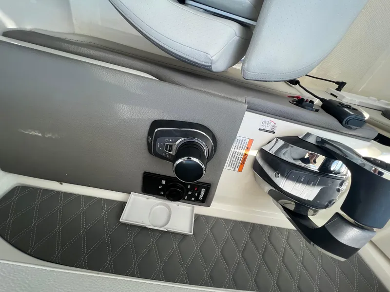 Slide: The Image of 2022 Sea Ray SLX 310 boat control panel with joystick and steering wheel. - 23