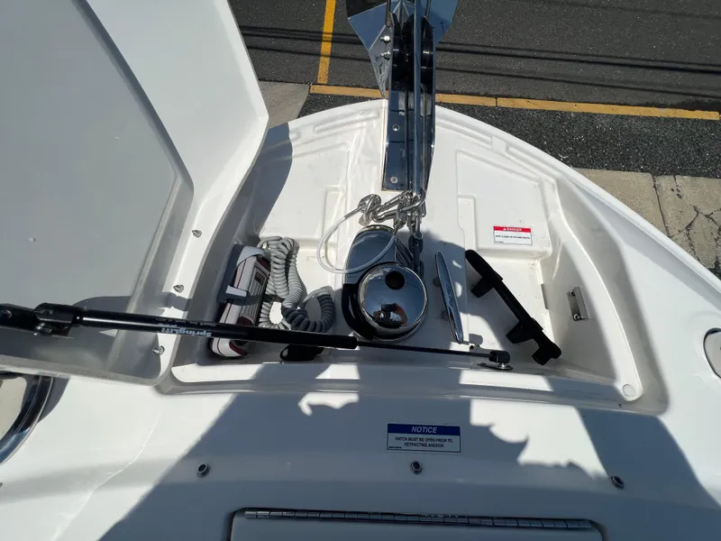 Slide: The Image of 2022 Sea Ray SLX 310 boat anchor compartment with equipment and safety notices. - 27