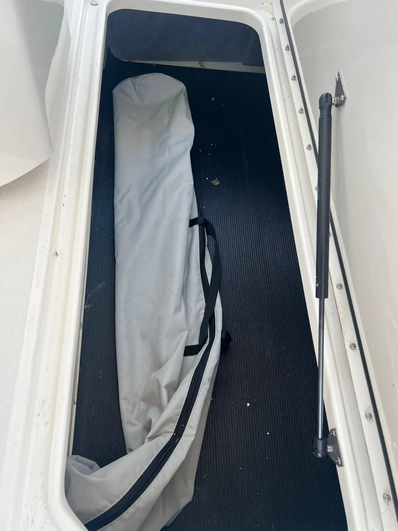 Slide: The Image of Storage compartment in a 2022 Sea Ray SLX 310 boat with a folded cover inside. - 33