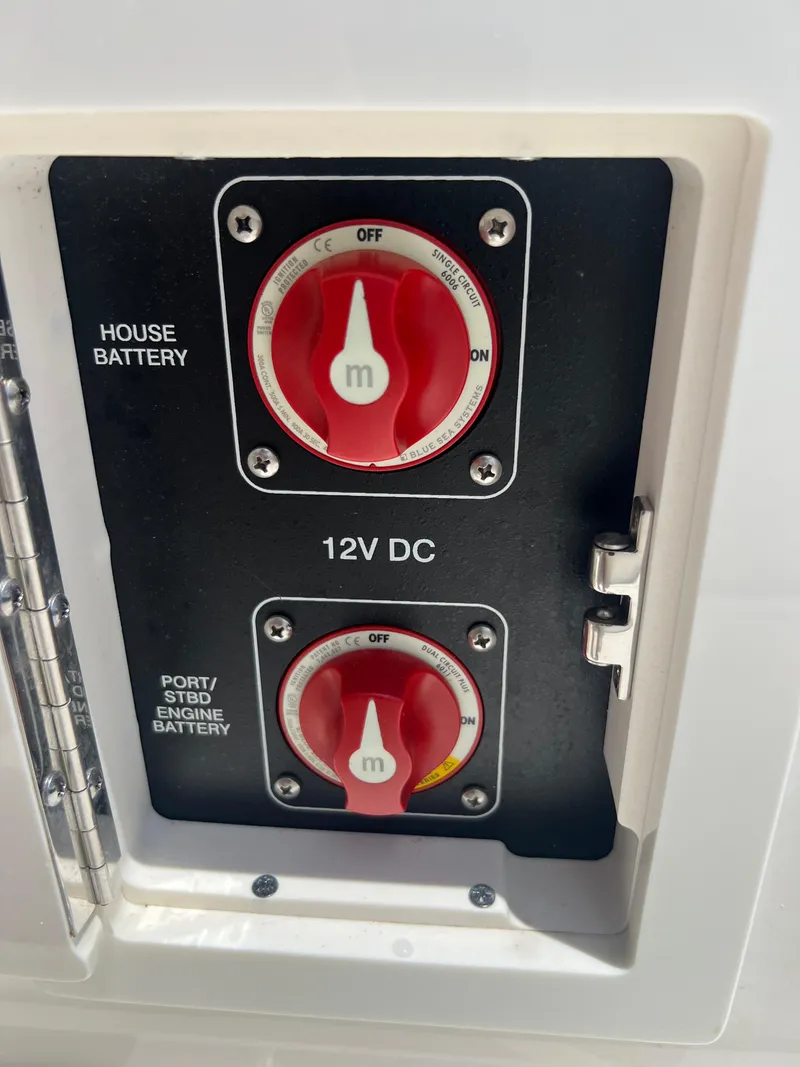 Slide: The Image of Battery control panel on a 2022 Sea Ray SLX 310 boat, featuring 12V DC switches. - 35