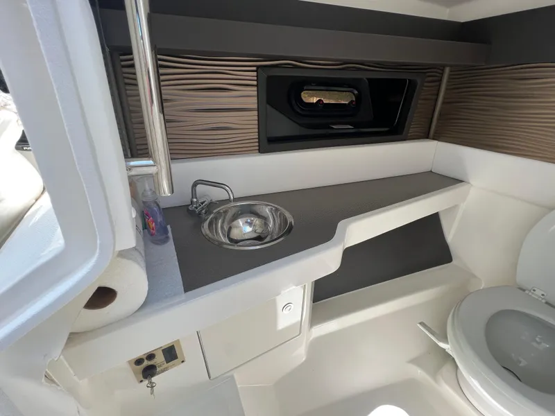Slide: The Image of 2022 Sea Ray SLX 310 boat interior with sink, toilet, and window. - 40