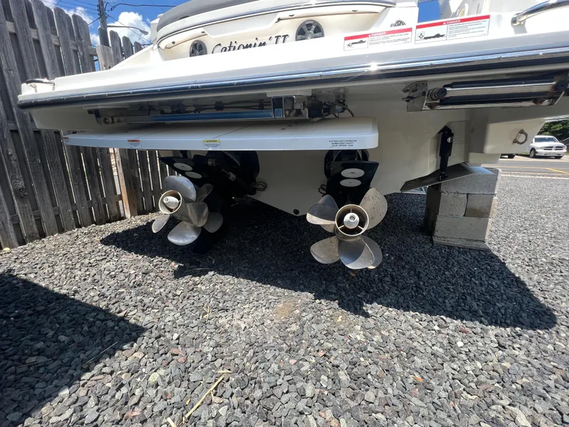 Slide: The Image of 2022 Sea Ray SLX 310 boat stern with dual propellers on gravel surface. - 5