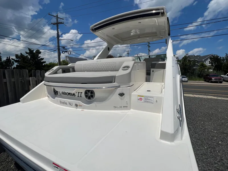 Slide: The Image of 2022 Sea Ray SLX 310 boat with spacious deck and seating, parked outdoors. - 6