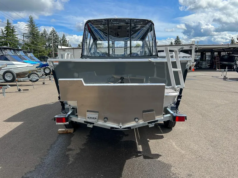 Slide: The Image of 2023 Hewescraft 200 PRO V ET boat, rear view, parked outdoors under cloudy sky. - 4