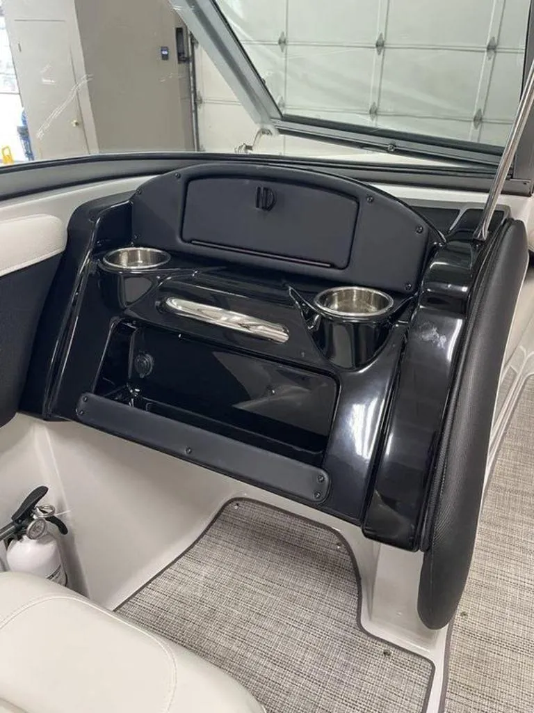 Slide: The Image of 2020 Crownline 205 SS boat interior with cup holders and storage compartment. - 13