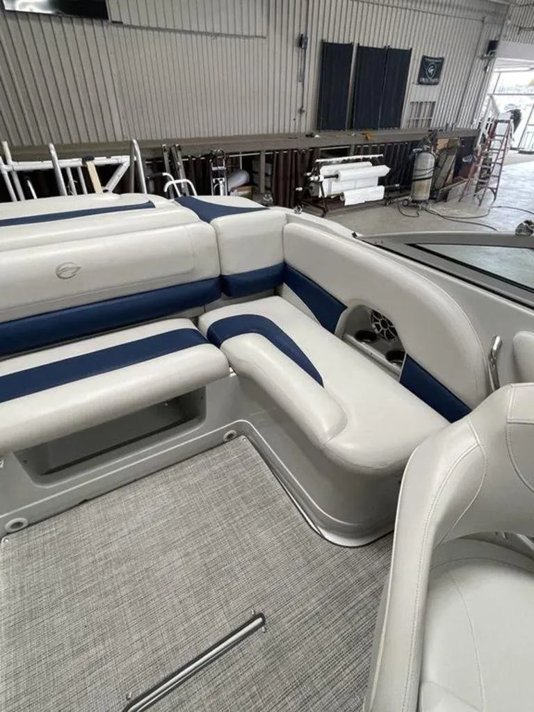 Slide: The Image of 2020 Crownline 205 SS boat interior with white and blue seating in a workshop. - 18