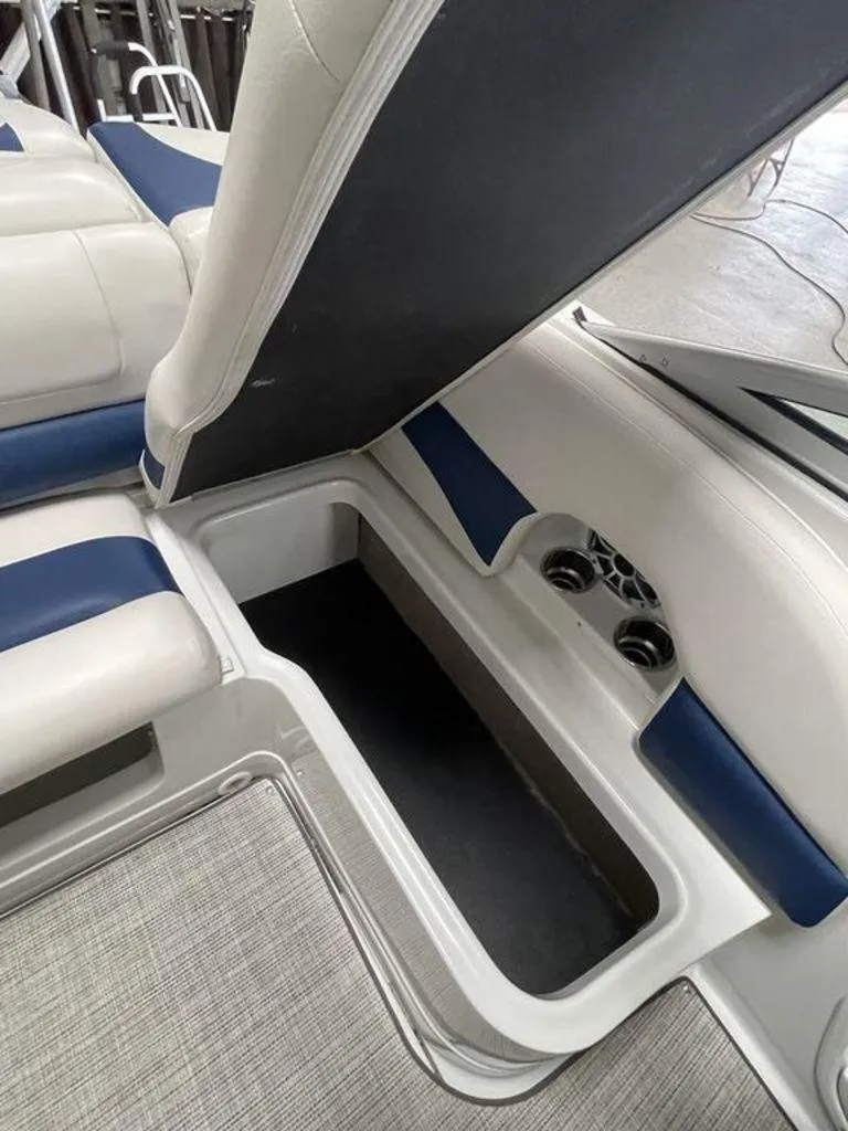 Slide: The Image of 2020 Crownline 205 SS boat interior storage compartment with blue and white seating. - 19