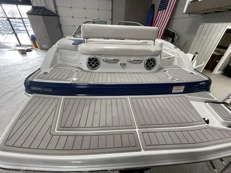 Slide: The Image of 2020 Crownline 205 SS boat with spacious deck and seating in a showroom. - 7