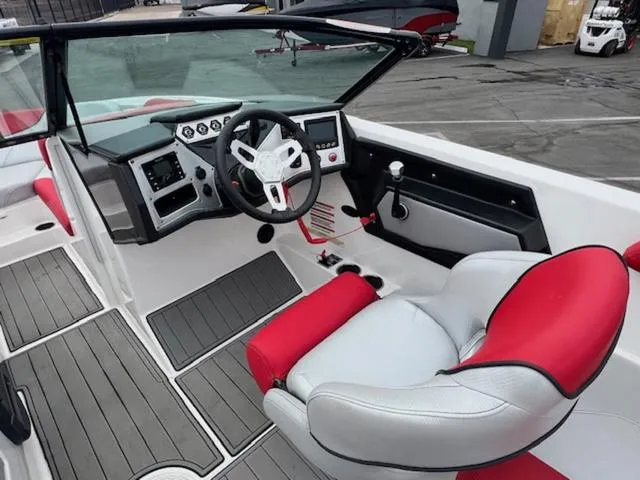Slide: The Image of 2018 MasterCraft NXT22 boat interior with red and gray seating, steering wheel, and dashboard. - 11