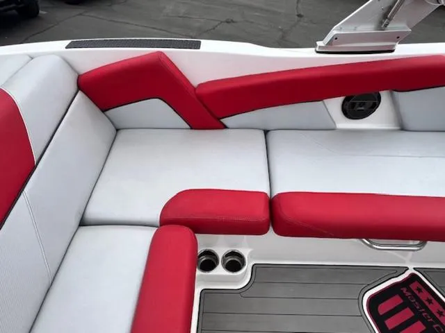 Slide: The Image of 2018 MasterCraft NXT22 boat interior with red and white seating and cup holders. - 13