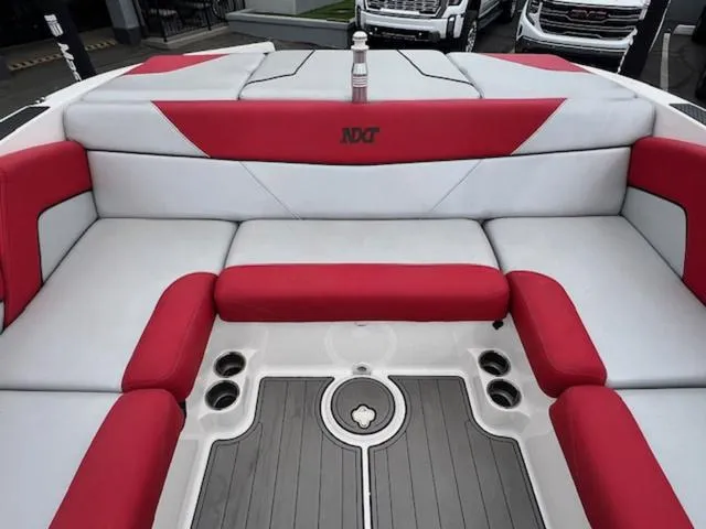 Slide: The Image of 2018 MasterCraft NXT22 boat interior with red and white seating, featuring cup holders. - 14