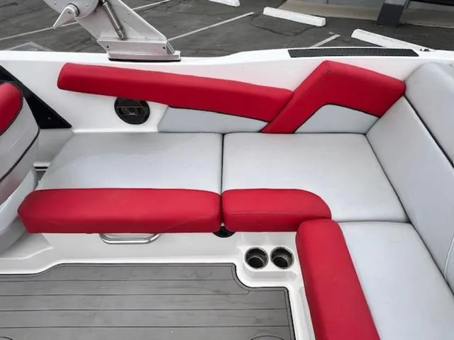 Slide: The Image of 2018 MasterCraft NXT22 boat interior with red and white seating, cup holders, and sleek design. - 15