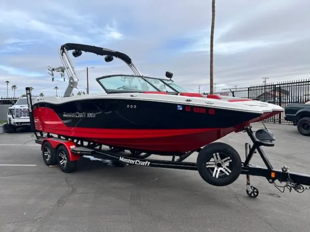 Slide: The Image of 2018 MasterCraft NXT22 boat on trailer, red and black design, parked outdoors. - 4