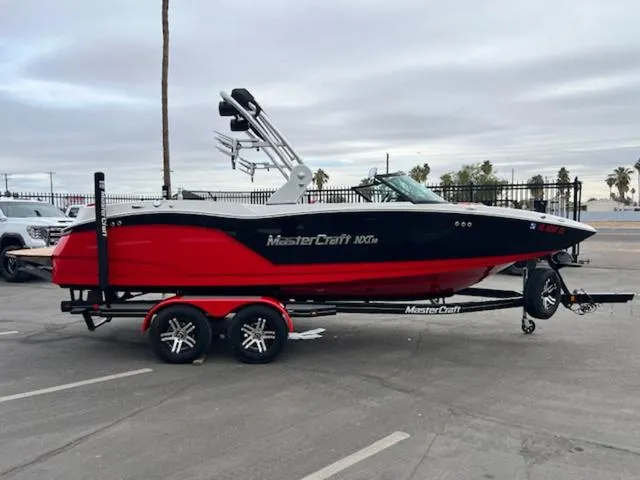 Slide: The Image of 2018 MasterCraft NXT22 boat on trailer, red and black design, parked outdoors. - 5