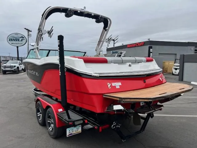 Slide: The Image of 2018 MasterCraft NXT22 boat on trailer, red and white, parked at dealership. - 8