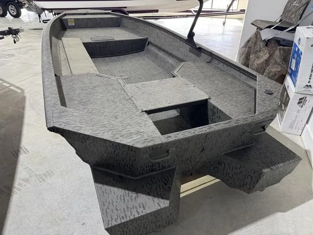 Slide: The Image of 2025 War Eagle MODEL 750 - GLADIATOR boat, camo design, displayed indoors. - 3
